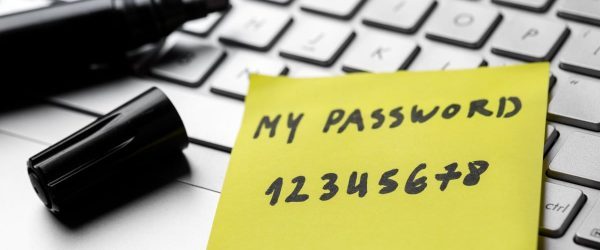 sticky note with weak easy password on laptop keyboard