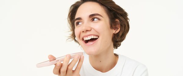 image-woman-records-voice-message-smartphone-talking-speakerphone-stands-white-min