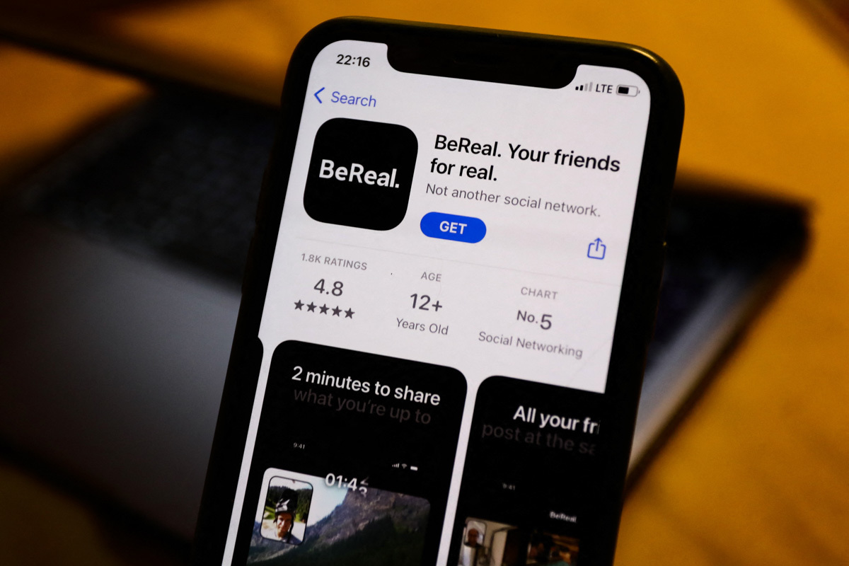 BeReal on the App Store displayed on a phone screen and a laptop in the background are seen in this illustration photo taken in Poland on August 7, 2022. (Photo by Jakub Porzycki/NurPhoto) (Photo by Jakub Porzycki / NurPhoto / NurPhoto via AFP)