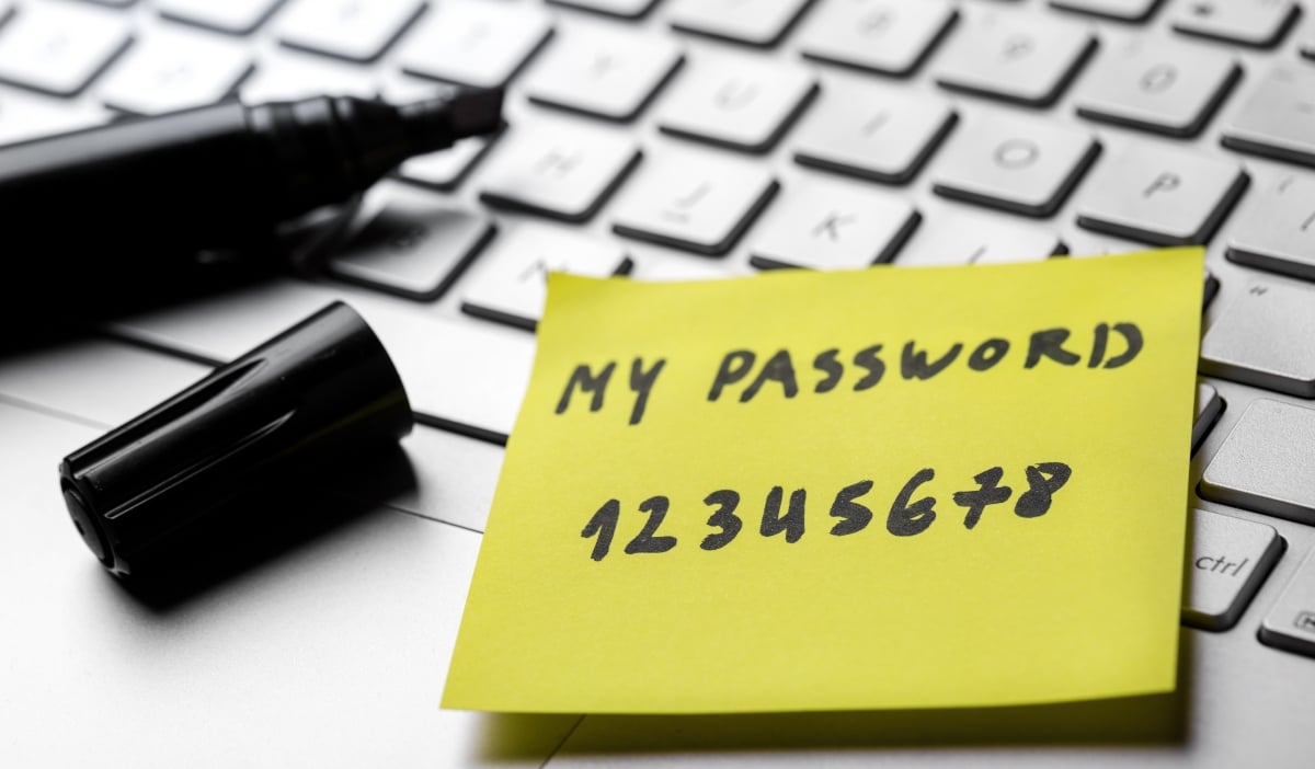 sticky note with weak easy password on laptop keyboard